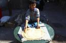 A boy makes bread in Duma neighbourhood, in Damascus