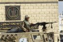 An Egyptian army soldier guards on an armoured personnel carrier in front of the main gate of Torah prison