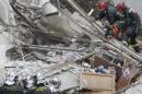 French firefighters search the rubble of a collapsed building in Rosny-Sous-Bois