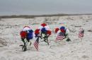 A small memorial stands in the sand along Highway 98 in Navarre, Fla., Thursday, March 12, 2015. Divers have found the military helicopter that crashed in dense fog Tuesday night during a Florida training mission, killing seven elite Marines and four experienced soldiers. (AP Photo/Northwest Florida Daily News, Jennie McKeon)