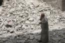 A man walks past the rubble of damaged buildings after an airstrike in the rebel held area of Aleppo's Baedeen district