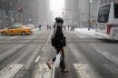 A woman crosses a street during a snow storm in New York on January 26, 2015