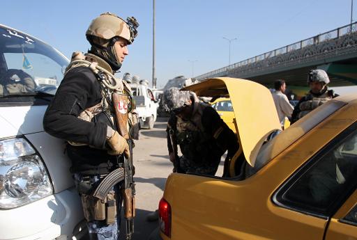 Iraqi security forces search the boot of a car at a checkpoint in Baghdad, on December 16, 2013