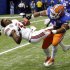 Florida linebacker Jon Bostic (1) hits Louisville quarterback Teddy Bridgewater (5) hard enough to dislodge his helmet in the first quarter of the Sugar Bowl NCAA college football game Wednesday, Jan. 2, 2013, in New Orleans. (AP Photo/Bill Haber)