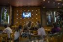 People in a restaurant watch a live speech by Argentina's President Cristina Fernandez during her first public comments since the mysterious death of special prosecutor Alberto Nisman, in Buenos Aires, Argentina, Monday, Jan. 26, 2015. Nisman was found dead Jan. 18 in his apartment, the day before he was scheduled to elaborate on explosive allegations that Fernandez shielded Iranian officials suspected in the largest terrorist attack in the South American country's history. (AP Photo/Ivan Fernandez)