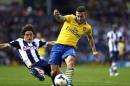 Arsenal's English midfielder Jack Wilshere (R) shoots at goal in front of West Bromwich Albion's English defender Billy Jones (L) at The Hawthorns in West Bromwich on October 6, 2013