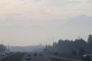 Haze from smoke covers a highway in Anchorage, Alaska, Thursday, May 22, 2014. Residents in Anchorage woke up Thursday to a smokey haze and the smell of a campfire over the state's largest city. The smoke is from wildfires burning on Alaska's Kenai Peninsula. (AP Photo/Mark Thiessen)