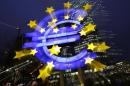 An illuminated euro sign is seen in front of the headquarters of the European Central Bank in the late evening in Frankfurt
