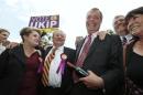 The leader of Britain's UKIP party, Nigel Farage, laughs after receiving a bottle of British wine from a supporter in South Ockendon