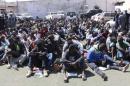 Migrants sit at a detention center after they were detained by the Libyan authorities in Tripoli