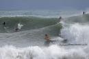 Surfers ride the waves in the waters at La Pared Beach in Luquillo, Puerto Rico, Tuesday, Oct. 14, 2014. Hurricane Gonzalo moved away from the area, but churned up heavy surf across much of the Caribbean, Tuesday. Forecasters said it could pick up strength and become a major storm as it approaches Bermuda. (AP Photo/Ricardo Arduengo)