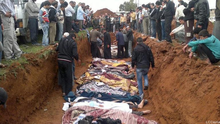 A picture by the opposition Local coordination Committees in Syria (LCC) purportedly shows people standing around a mass grave in the town of Taftnaz, on April 5, 2012