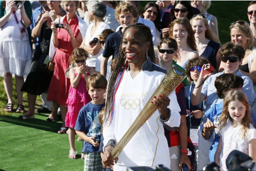 Venus Williams of the U.S. waits with the Olympic Torch on Murray Mound at the All England Lawn Tennis Club before the start of the London 2012 Olympic Games in London