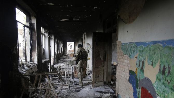 A Ukrainian soldier inspects a destroyed school in Pisky village near Donetsk, in October 2015