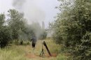 A Free Syrian Army fighter is seen near a mortar in Khirbet Ghazaleh