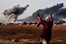 A woman near the Turkish border village of Mursitpinar reacts as smoke rises from the Syrian town of Kobane after air strikes from the US-led coalition on jihadist militants on October 13, 2014