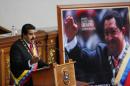 FILE - In this Jan. 21, 2015 file photo, Venezuela's President Nicolas Maduro delivers his annual state-of-the-nation address beside a framed poster featuring the late President Hugo Chavez, at the National Assembly in Caracas, Venezuela. While the arrest of Caracas Mayor Antonio Ledezma in Feb. 2015 provoked spontaneous demonstrations and drew international condemnation, it also reminded many Venezuelans of what they most disliked about the politicians who preceded Maduro and his late mentor Hugo Chavez at a time when the socialist government faces an economic crisis that has sent the president's popularity plummeting. (AP Photo/Ariana Cubillos, File)