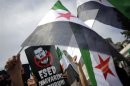 Demonstrators wave Syrian opposition flags during a protest against Syria's President Bashar al-Assad at the courtyard of Fatih mosque in Istanbul
