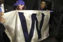 Democratic presidential candidate Hillary Clinton holds a 'W' banner as the Chicago Cubs win the World Series baseball Game 7 against the Cleveland Indians after her final campaign rally of the day at Arizona State University in Tempe, Ariz., Wednesday, Nov. 2, 2016. (AP Photo/Andrew Harnik)