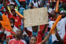 A football fan holds a sign reading "Stop Ebola in Africa" ahead of a 2015 African Cup of Nations group A football match in Bata, Equatorial Guinea, on January 17, 2015