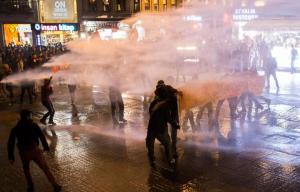 Police use a water cannon to try to disperse people …