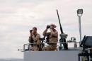 Military personnel scan the horizon from the deck of the Belgian Navy Vessel Godetia, one of the fleet of EU Navy Vessels taking part in the Triton migrant rescue operation, as it leaves the Augusta harbour on June 18, 2015, in Italy