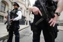 Armed police officers hold guns as they stand in Downing Street, in central London on August 29, 2014