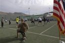 U.S. troops play touch football in the early morning hours on Thanksgiving at a military base in Kabul