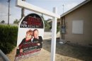 A real estate sign is seen outside a deserted home stripped of its copper wiring in San Bernardino