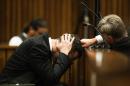 South African Paralympic athlete Oscar Pistorius (left) covers his ears with his hands while a witness recounts the night of the crime during the trial for the murder of his girlfriend Reeva Steenkamp at Pretoria court on March 6, 2014