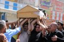 Iraqis carry the coffin of a victim of a sectarian attack, in a Baghdad funeral procession on September 12, 2013