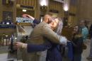 Philadelphia Mayor Michael Nutter hugs Mary Schaheen, the first passenger in line for Train 110 at Philadelphia's 30th Street Station, Monday, May 18, 2015, as Amtrak trains began rolling on the busy Northeast Corridor early Monday, the first time in almost a week following a deadly crash in Philadelphia. (AP Photo/Michael R. Sisak)