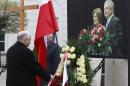 Poland's ruling party leader, Jaroslaw Kaczynski, lays a wreath in front of the portrait of his late twin brother, the former President Lech Kaczynski, and his wife Maria Kaczynska, at the Presidential Palace in Warsaw, Poland, on Sunday, April 10, 2016, during ceremonies marking six years since the presidential couple and dozens of other state officials were killed in a plane crash in Russia. (AP Photo/Czarek Sokolowski)