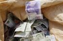Chinese Yuan bank notes are seen in a vendor's cash sack at a market in Beijing