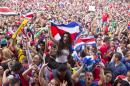 Costa Rica soccer fans celebrate a goal against Greece as they watch the World Cup round of 16 match on TV set up in a public square in San Jose, Costa Rica, Sunday, June 29, 2014. (AP Photo/Esteban Felix)