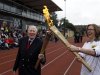 The Olympic Flame is passed between Sir Roger Bannister and Oxford doctoral student Nicola Byrom on the running track at Iffley Road Stadium in Oxford, England, Tuesday July 10, 2012. Bannister was the first person ever to run a sub four-minute-mile, on May 6, 1954, at this track in Oxford. Bannister returned to the site of his greatest sporting achievement, to participate in the Olympic Torch relay as the Olympic flame is carried around the country to the opening ceremony of the 2012 London Olympic Games. (AP Photo/Lefteris Pitarakis)