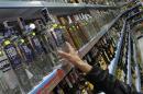 A customer takes a bottle of vodka from a shelf in a Russian supermarket in Benidorm