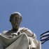 FILE- In this June 5, 2012, file photo, the marble statue of ancient Greek philosopher Plato, stands in front of the Athens Academy, as the Greek flag flies in Athens. Bankers, governments and investors are starting to prepare for Greece to drop the euro currency, a move that could spread turmoil throughout the global financial system. A Greek election on Sunday, June 12, 2012, will go a long way toward determining whether it happens. (AP Photo/Dimitri Messinis, File)