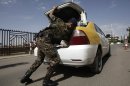 A policeman checks a car at the entrance of Sanaa International Airport, in Yemen, Wednesday, Aug. 7, 2013. The State Department on Tuesday ordered non-essential personnel at the U.S. Embassy in Yemen to leave the country. The department said in a travel warning that it had ordered the departure of non-emergency U.S. government personnel from Yemen "due to the continued potential for terrorist attacks" and said U.S. citizens in Yemen should leave immediately because of an "extremely high" security threat level. (AP Photo/Hani Mohammed)