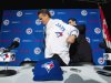 Toronto Blue Jays General Manager Alex Anthopoulos, right, helps new Blue Jays manager John Gibbons, put on his jersey before speaking to he media during a press conference in Toronto on Tuesday, Nov. 20, 2012. (AP Photo/The Canadian Press, Nathan Denette)