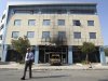 A security guard walks outside Microsoft's offices in northern Athens, Wednesday, June 27, 2012. Assailants attacked the offices of Microsoft early Wednesday, driving a van through the front doors and setting off an incendiary device that burned the building entrance, police said. (AP Photo/Thanassis Stavrakis)