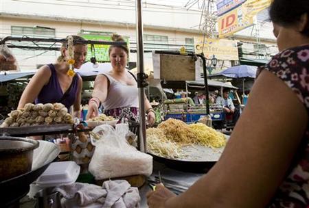 Tourists select food from …