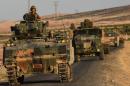 Turkish soldiers stand in a Turkish army tank driving back to Turkey from the Syrian-Turkish border town of Jarabulus