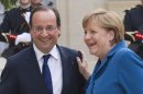 French President Francois Hollande, left, welcomes German Chancellor Angela Merkel at the Elysee Palace, Wednesday, June 27, 2012. Germany's Chancellor Angela Merkel says she hopes European leaders adopt a €130 billion ($162 billion) stimulus package this week, in a gesture to French President Francois Hollande despite their differences over how to end Europe's spiraling debt crisis. The two leaders went into talks Wednesday night sharply opposed over whether to share debt among the 17 nations that use the euro, and how much sovereignty to surrender over national budgets. (AP Photo/Michel Euler)