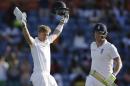 England's Joe Root, left, celebrates with teammate England's Ben Stokes after scoring a century against West Indies on the third day of their second Test match at the National Stadium in St. George's, Grenada, Thursday, April 23, 2015. (AP Photo/Ricardo Mazalan)