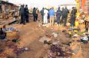 Nigerian security inspect the scene of a bomb blast at the Jos Terminus Market, on December 12, 2014