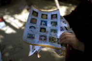 Ye Jinxiu, 59, displays pictures of missing children on the streets of Fuzhou on China's east coast Fujian province, on October 23, 2013