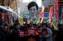 An effigy of South Korean President Park Geun-hye is seen behind people marching towards the Presidential Blue House during a protest calling for South Korean President Park Geun-hye to step down in central Seoul