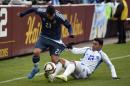 El Salvador's Alexander Larin (13) pulls on the shorts of Carlos Tevez (23) during the first half of an international friendly, Saturday, March 28, 2015, in Landover, Md. (AP Photo/Nick Wass)