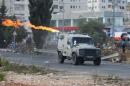 Molotov cocktail is thrown by Palestinians at an Israeli army jeep during clashes near the Jewish settlement of Bet El, near the West Bank city of Ramallah